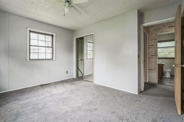 carpeted empty room with a textured ceiling and ceiling fan