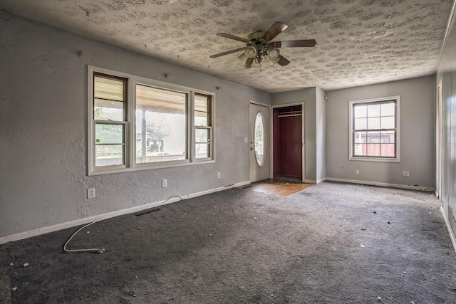 carpeted foyer with ceiling fan and a textured ceiling