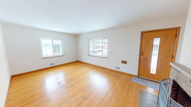 unfurnished living room featuring visible vents, baseboards, and light wood-style flooring