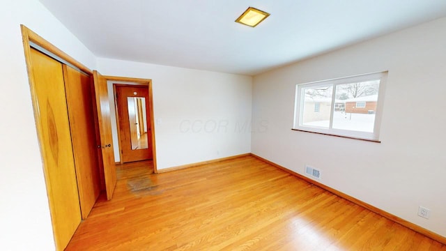 empty room featuring visible vents, baseboards, and light wood-style flooring