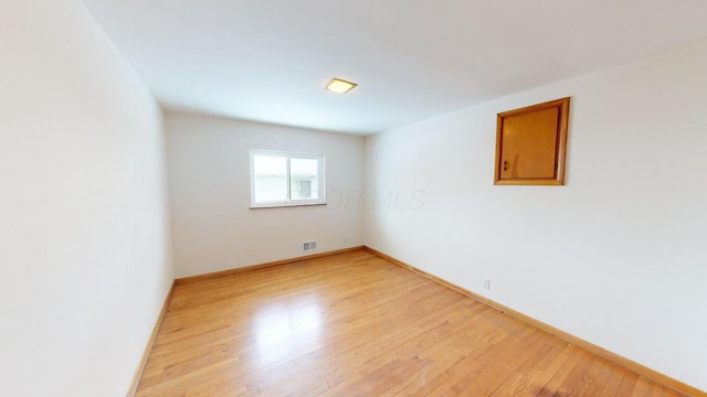 empty room with visible vents, baseboards, and light wood-style floors