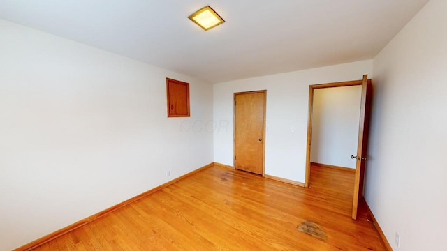 spare room with light wood-style flooring and baseboards