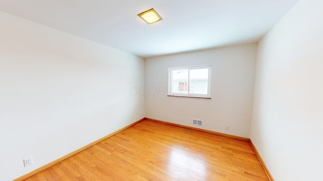 spare room with visible vents, baseboards, and light wood-style floors