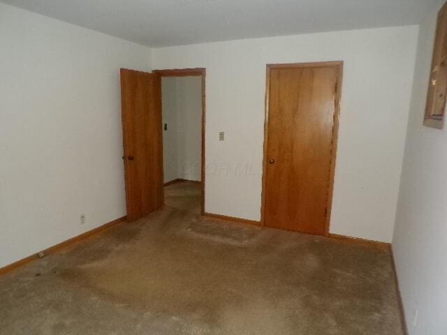 carpeted spare room with baseboards