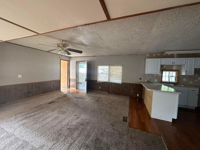 8565 Smith Calhoun Rd Unit 162, Plain City, OH 43064 - kitchen featuring a wainscoted wall, wooden walls, white cabinetry, ceiling fan, and open floor plan