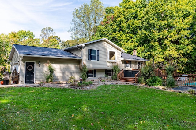 view of front of property with a front yard, a hot tub, and a garage