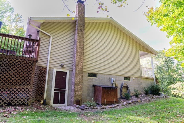 view of side of home with a lawn and a wooden deck