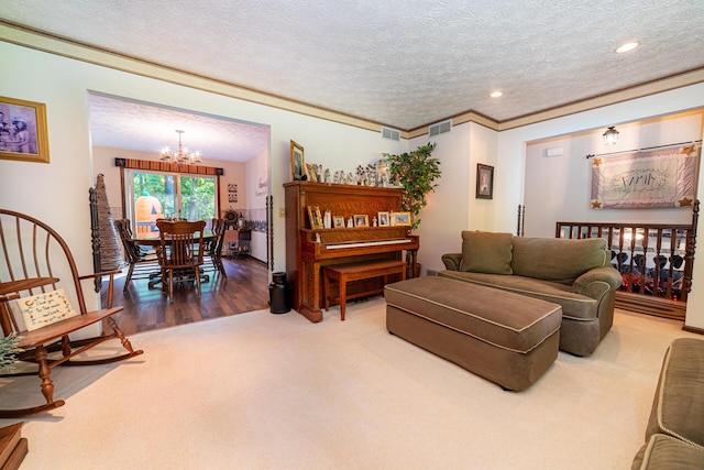 living room featuring a textured ceiling, crown molding, carpet, and a notable chandelier