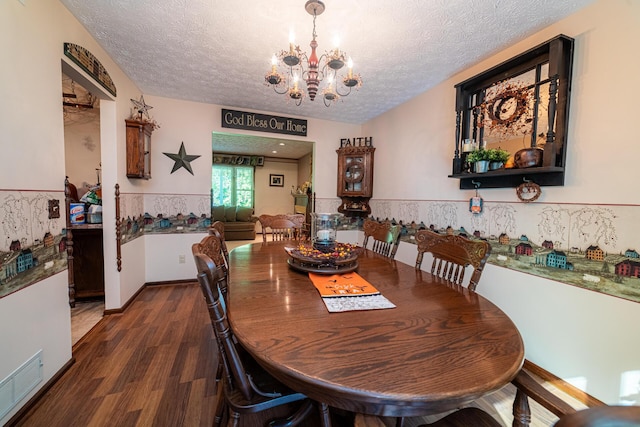 dining area with a notable chandelier, dark hardwood / wood-style floors, and a textured ceiling