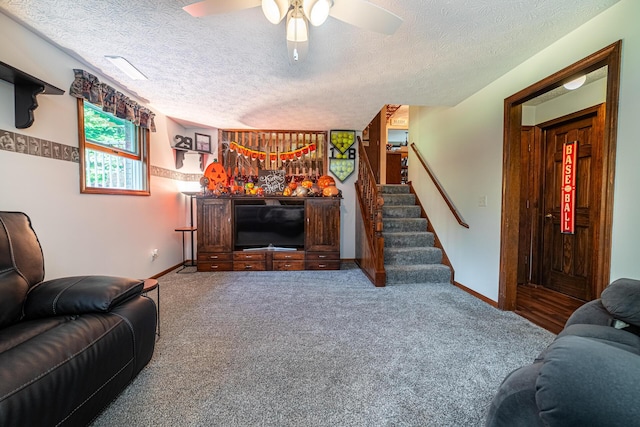 living room with a textured ceiling, ceiling fan, and carpet