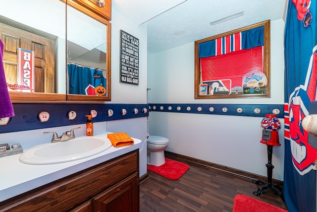 bathroom featuring toilet, a textured ceiling, wood-type flooring, and vanity