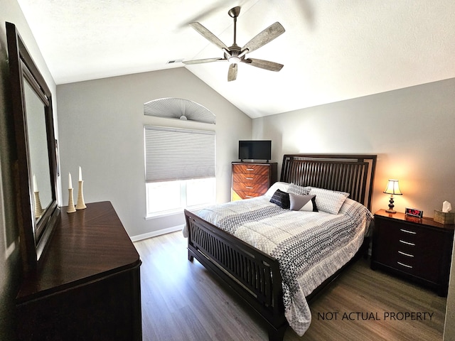 bedroom with vaulted ceiling, ceiling fan, and dark wood-type flooring