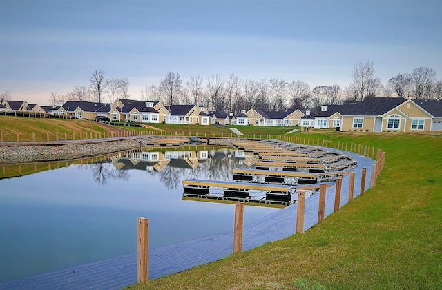 dock area featuring a water view and a lawn