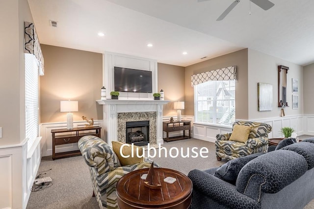 living room with ceiling fan, a fireplace, and light colored carpet