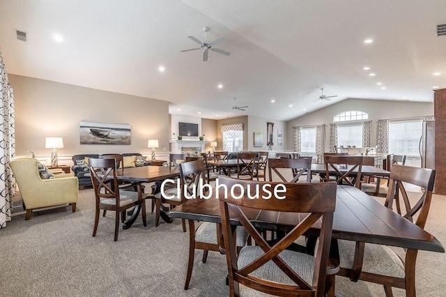 dining area featuring ceiling fan, light colored carpet, and lofted ceiling