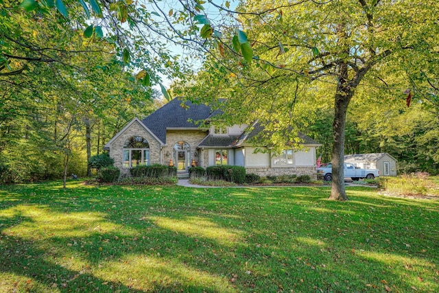 view of front of property with a front lawn and a shed