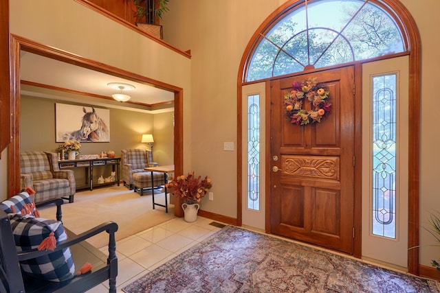 tiled entryway featuring a towering ceiling