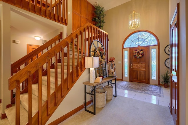 foyer with a chandelier, light tile patterned floors, and a towering ceiling