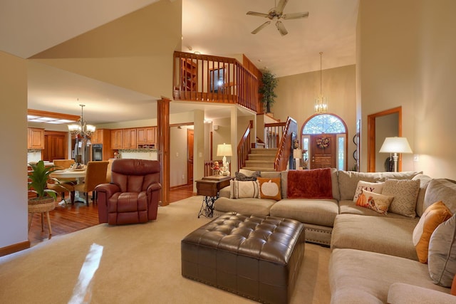 living room featuring ceiling fan with notable chandelier, light hardwood / wood-style floors, and high vaulted ceiling