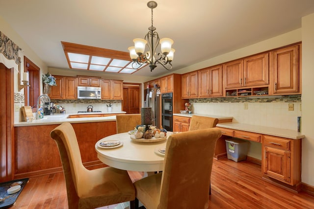 dining area with light hardwood / wood-style floors, an inviting chandelier, and sink