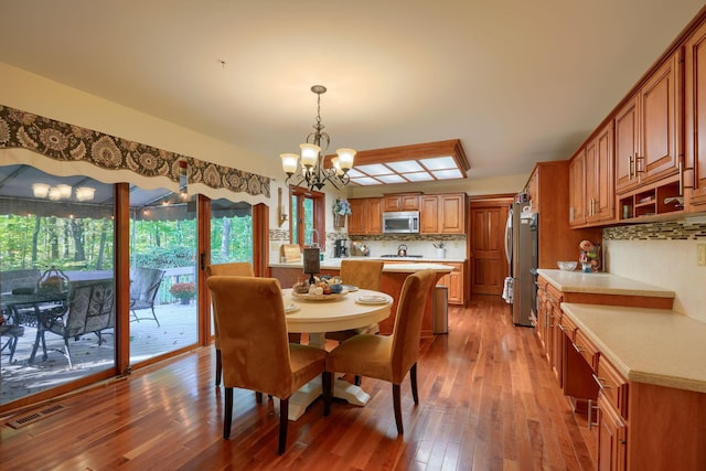 dining area with hardwood / wood-style flooring and a chandelier