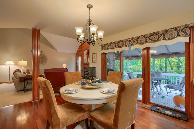 dining room featuring hardwood / wood-style floors, a chandelier, and vaulted ceiling