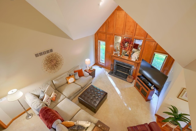 living room with high vaulted ceiling and a premium fireplace