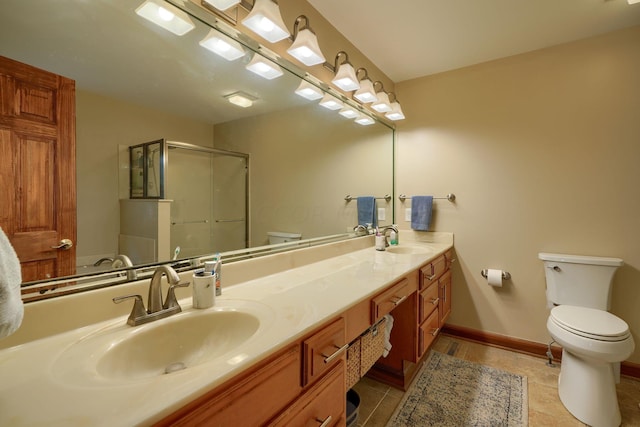 bathroom with tile patterned flooring, vanity, toilet, and a shower with shower door