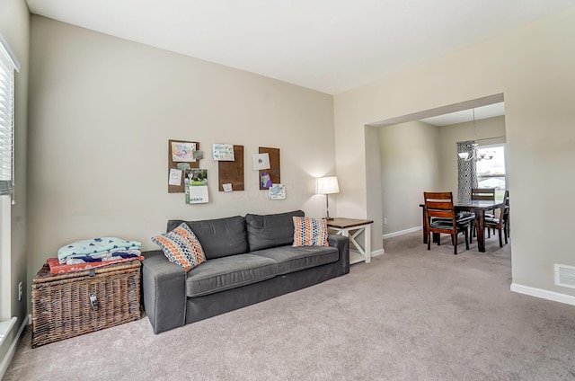 living room featuring carpet and a notable chandelier