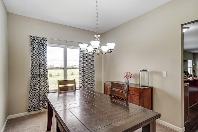 carpeted dining space with a notable chandelier