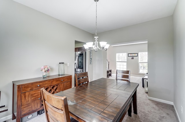 dining area featuring carpet flooring and a notable chandelier