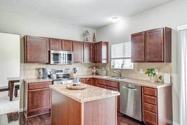 kitchen with sink, stainless steel appliances, tasteful backsplash, dark hardwood / wood-style floors, and a kitchen island