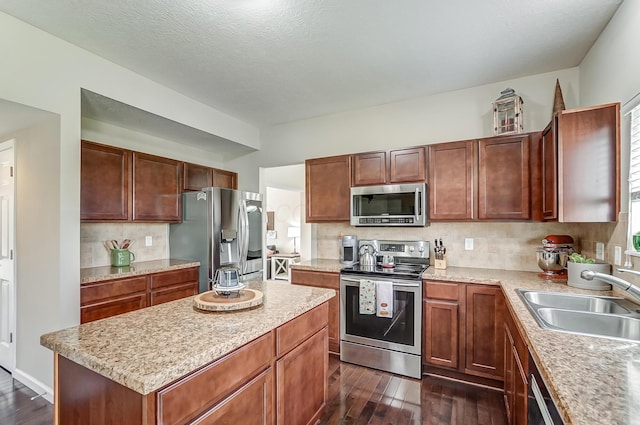 kitchen with sink, a textured ceiling, tasteful backsplash, dark hardwood / wood-style flooring, and stainless steel appliances