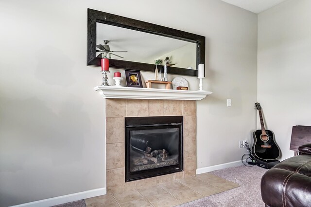 tiled living room featuring ceiling fan and a fireplace