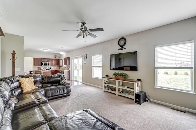 carpeted living room with ceiling fan