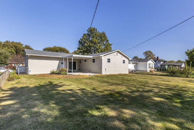 back of property with a patio area and a lawn