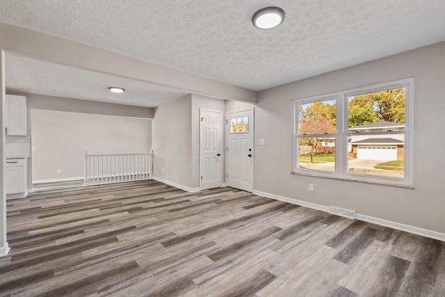 entryway with hardwood / wood-style floors and a textured ceiling