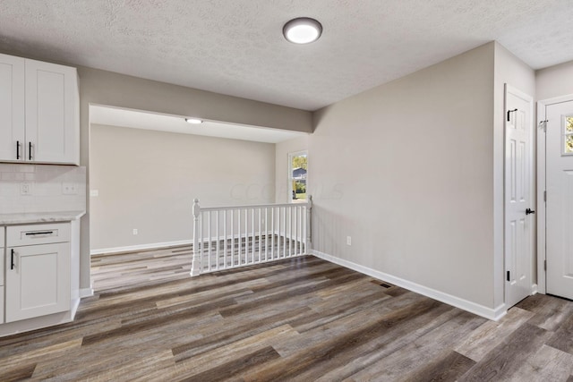 interior space with a textured ceiling and dark wood-type flooring