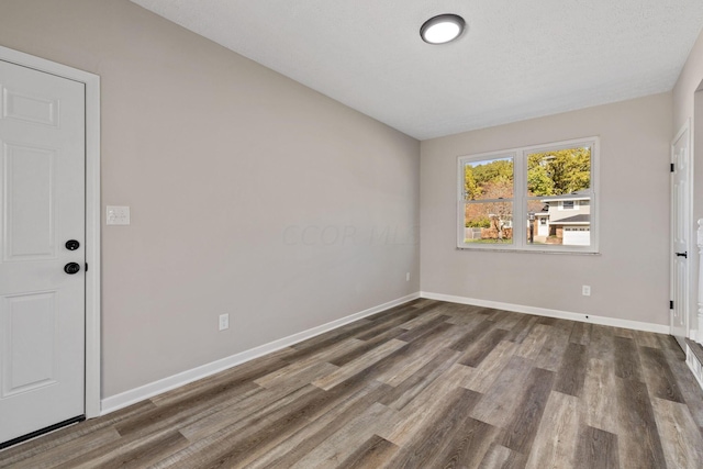 unfurnished room featuring hardwood / wood-style floors and a textured ceiling