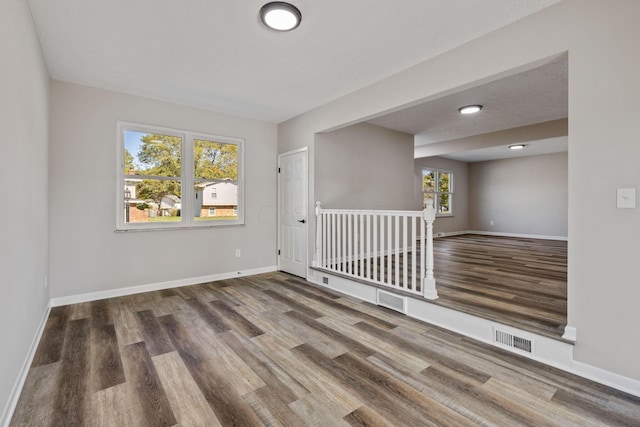 spare room with dark wood-type flooring and a textured ceiling