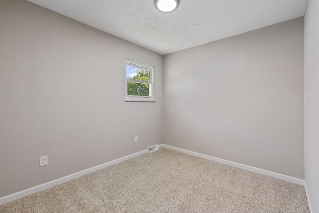 carpeted spare room with a textured ceiling