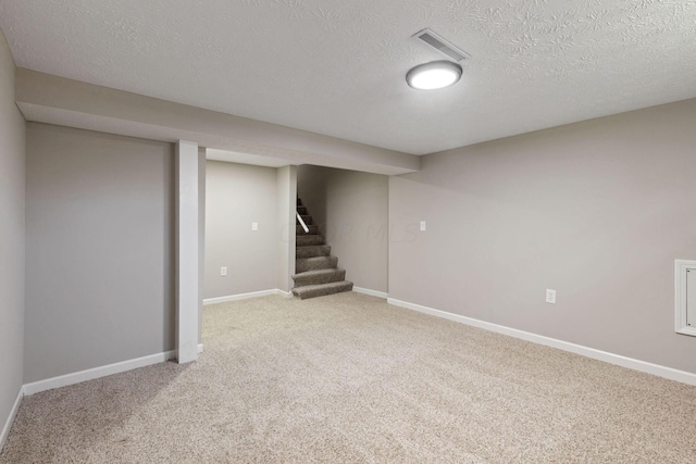 basement with light carpet and a textured ceiling