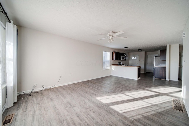 1109 Fairwood Ave, Columbus, OH 43206 - unfurnished living room with dark wood-type flooring, a ceiling fan, and a textured ceiling