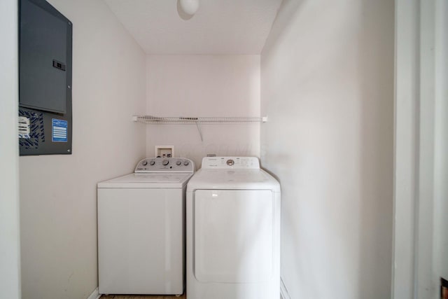 washroom with independent washer and dryer, a textured ceiling, and electric panel