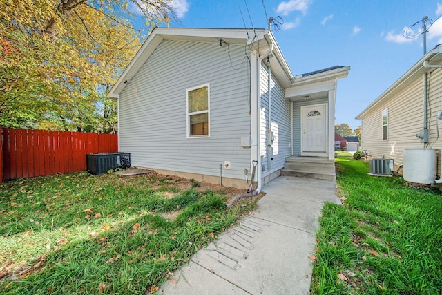 view of front of property with central air condition unit and a front lawn