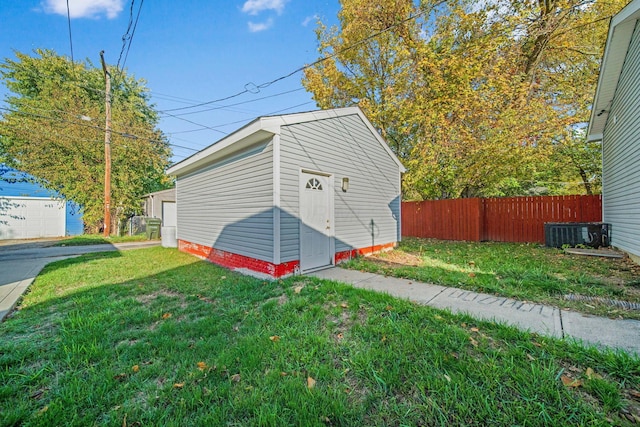 view of outdoor structure featuring a lawn and central air condition unit