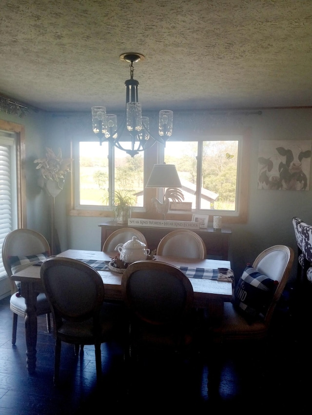 dining area featuring a chandelier, a textured ceiling, and plenty of natural light