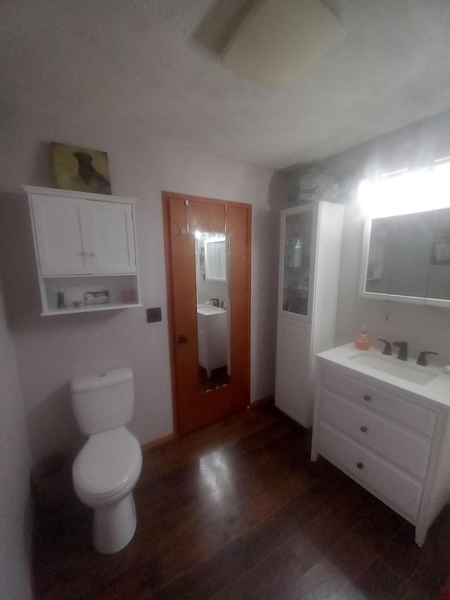 bathroom featuring hardwood / wood-style floors, vanity, and toilet