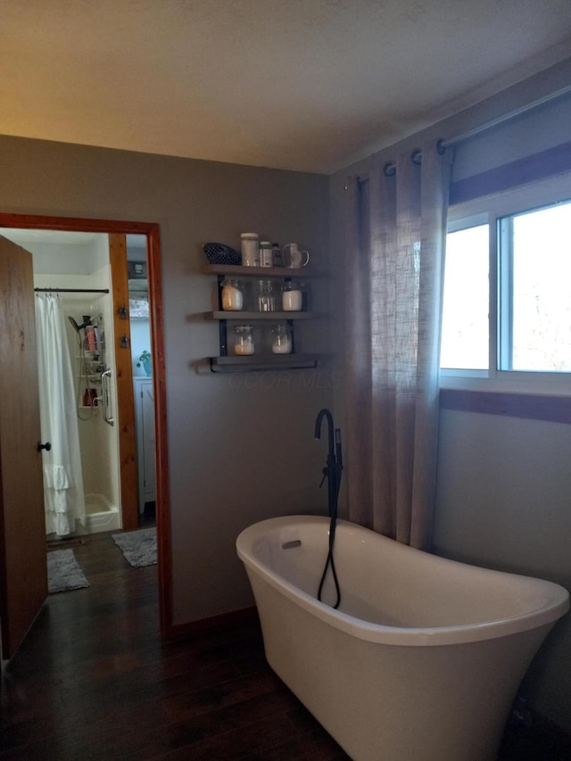 bathroom with plus walk in shower, hardwood / wood-style floors, and washer / clothes dryer