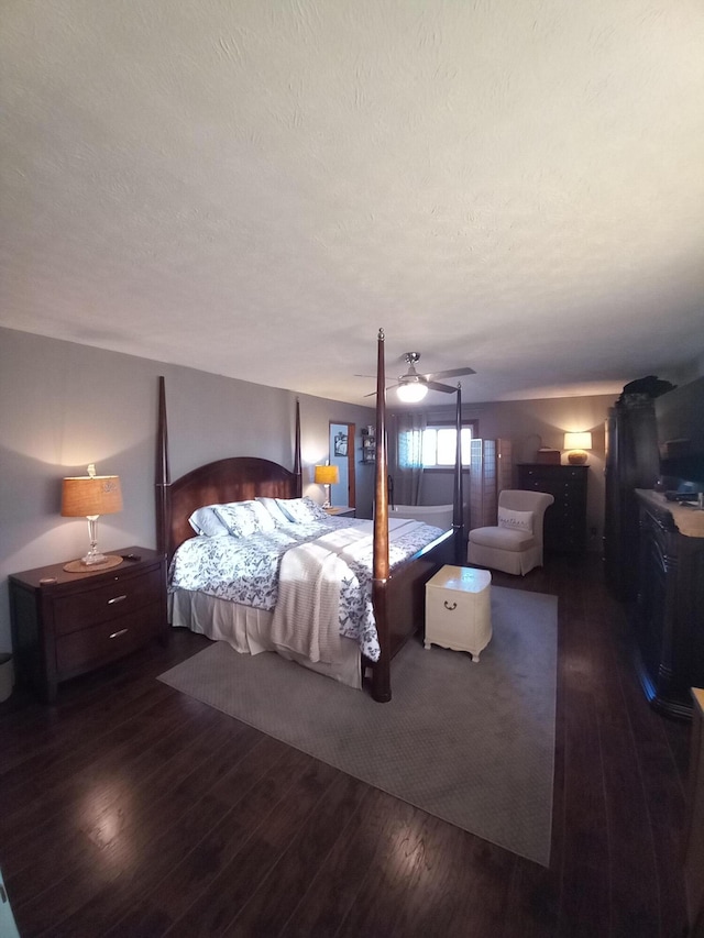 bedroom with a textured ceiling, ceiling fan, and dark hardwood / wood-style floors